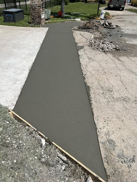 After: freshly poured and finished concrete strip beside the driveway